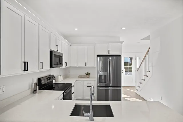a kitchen with stainless steel appliances a refrigerator and a stove top oven