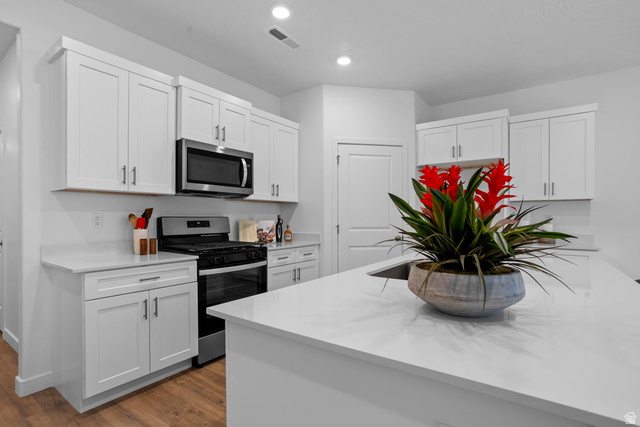 1624 South Staircase Way, Unit 4183 Washington, UT 84780 - Photo 21 of 47 Modern kitchen featuring white shaker-style cabinetry, a stainless steel microwave, a built-in oven with a gas range, and light-colored countertops