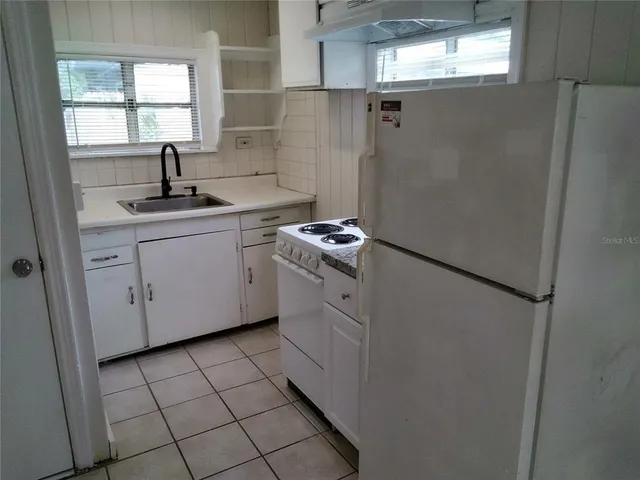 a kitchen with a sink cabinets and window