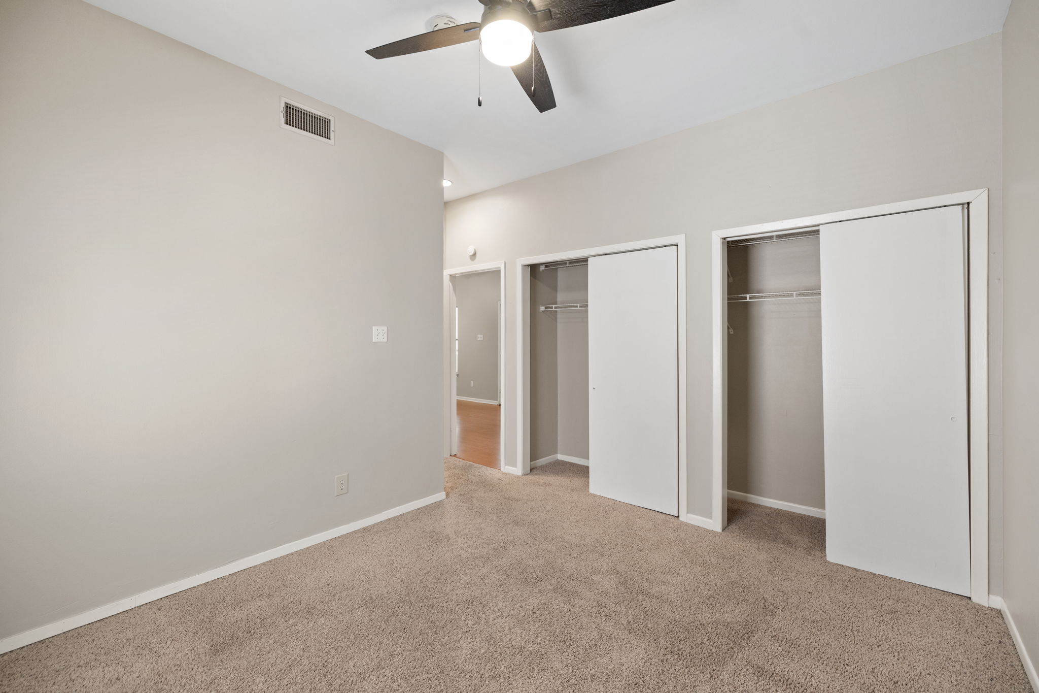 712 Graham Place, Unit 203 Austin, TX 78705 - Photo 18 of 30 an empty room with a ceiling fan and carpet