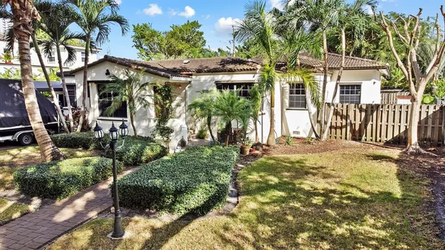a front view of a house with a garden