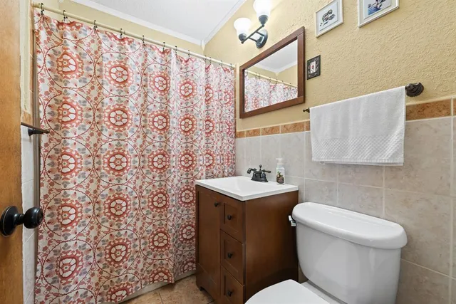 a bathroom with a toilet a sink and a shower curtain