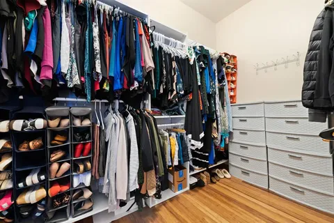 a view of walk in closet with clothes and shoes