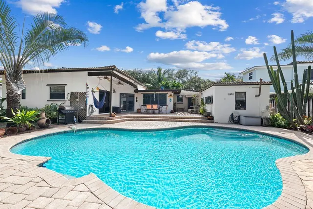 a view of a house with swimming pool and a chairs