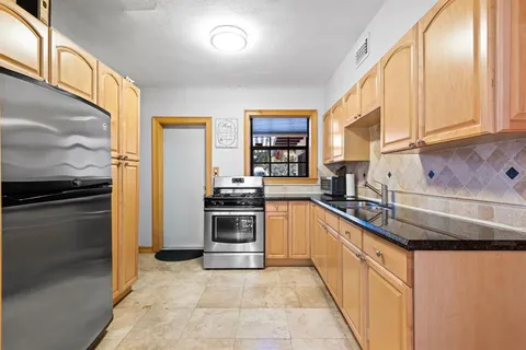 a kitchen with stainless steel appliances granite countertop a stove a sink and a refrigerator