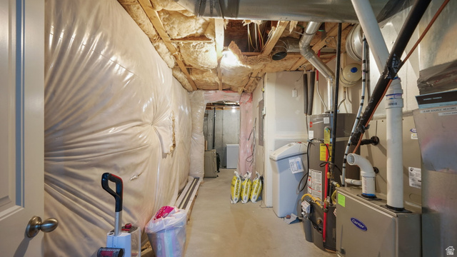 6062 Spring Street Stansbury Park, UT 84074 - Photo 23 of 36 Basement utility area featuring a Carrier furnace, water heater, water softener, and exposed ceiling joists with insulation