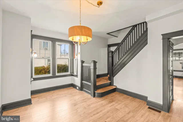 a view of a living room with hardwood floor and windows