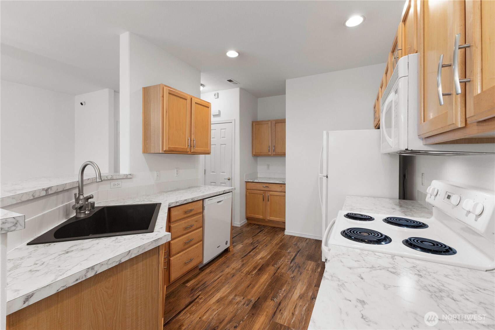 3220 Southeast 12th Street, Unit 1039 Renton, WA 98058 - Photo 11 of 27 a kitchen with a sink a stove a refrigerator and cabinets