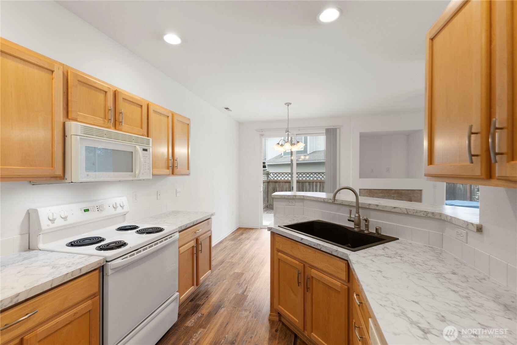 3220 Southeast 12th Street, Unit 1039 Renton, WA 98058 - Photo 12 of 27 a kitchen with stainless steel appliances granite countertop a sink a stove and a refrigerator