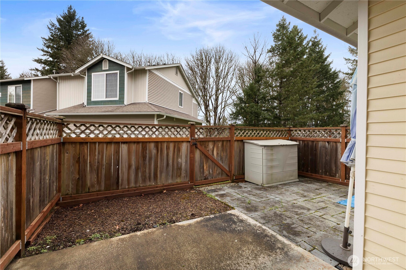 3220 Southeast 12th Street, Unit 1039 Renton, WA 98058 - Photo 25 of 27 a view of a wooden house with a fence
