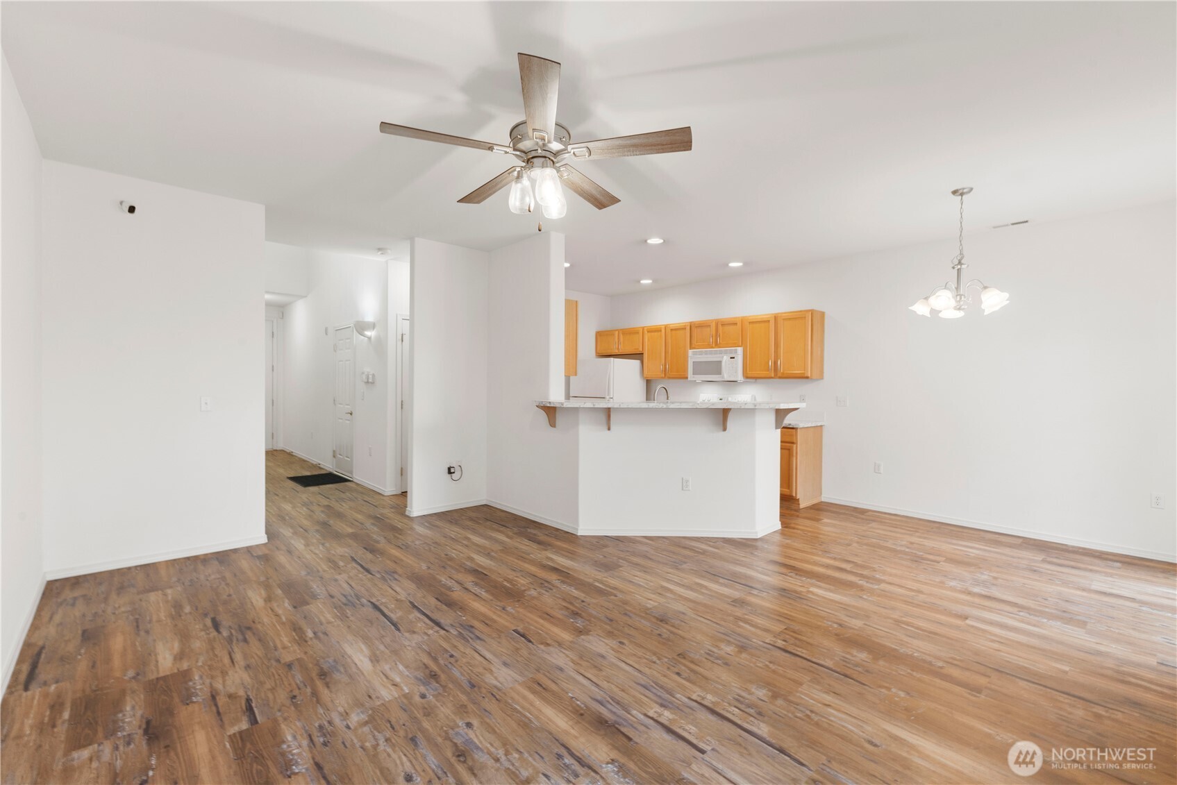 3220 Southeast 12th Street, Unit 1039 Renton, WA 98058 - Photo 7 of 27 a view of a kitchen with a microwave and wooden floor