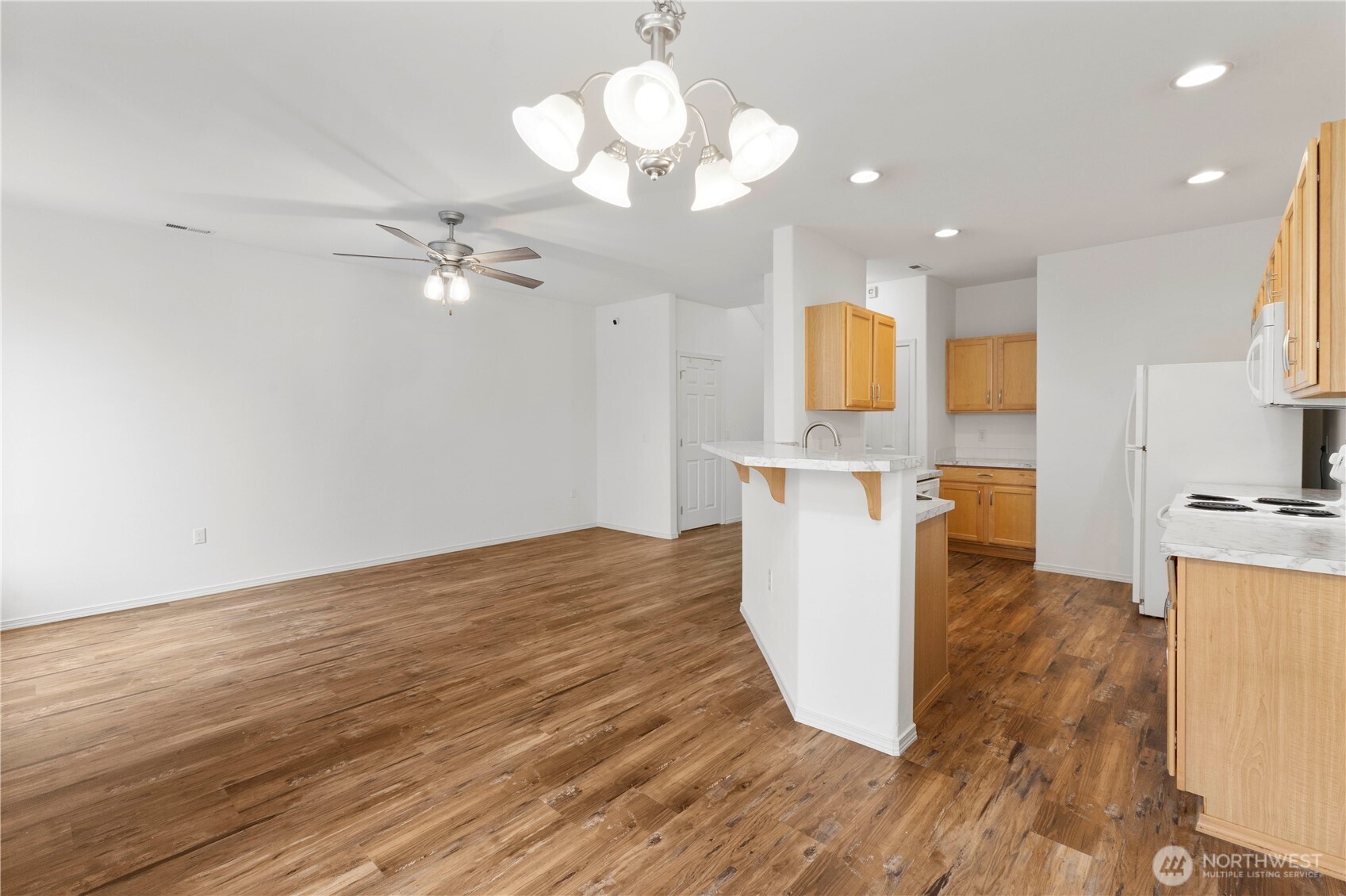 3220 Southeast 12th Street, Unit 1039 Renton, WA 98058 - Photo 10 of 27 a view of a kitchen with wooden floor and a chandelier