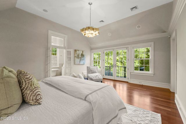 a bedroom with a large bed and a chandelier