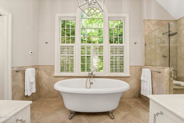a white bath tub sitting in a bathroom next to a window