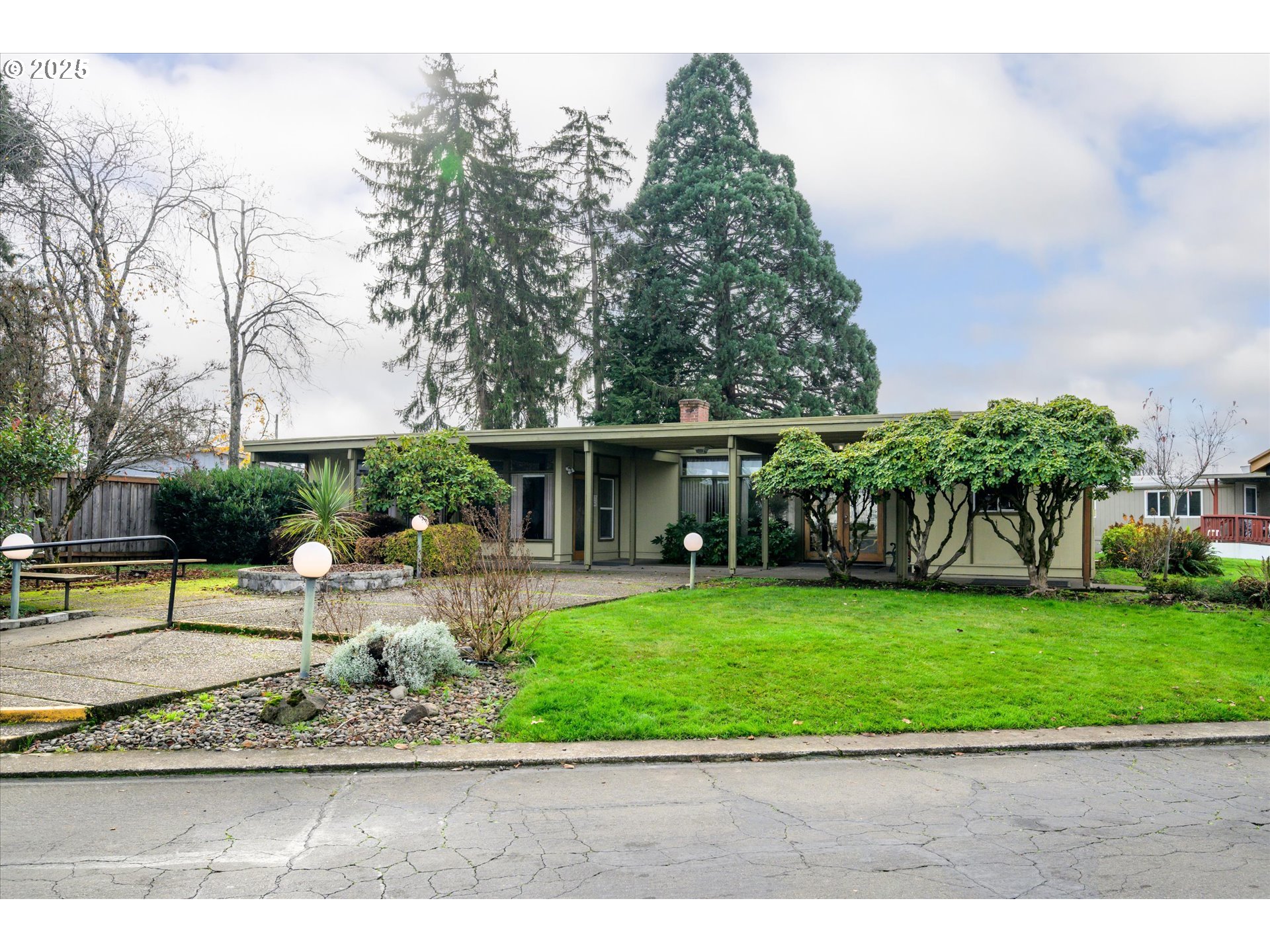 2150 Laura Street, Unit 111 Springfield, OR 97477 - Photo 29 of 30 a view of a garden with a bench in front of house
