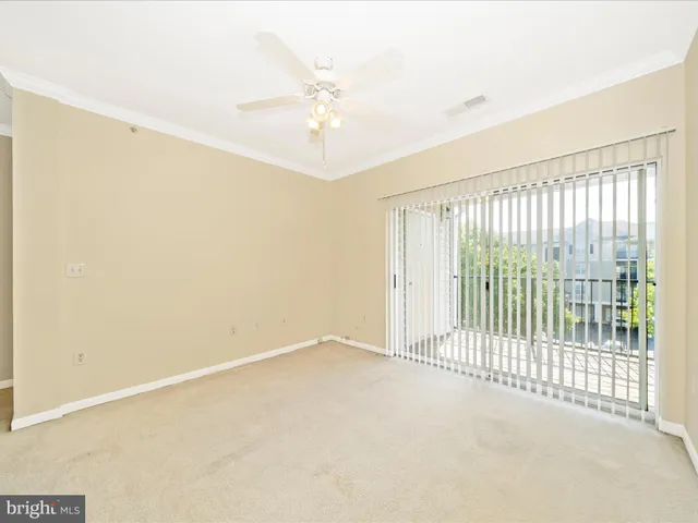 an empty room with windows and ceiling fan