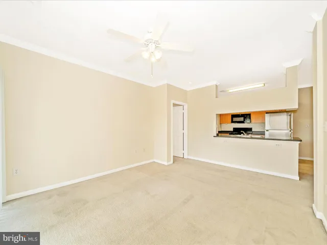 an empty room with windows and ceiling fan