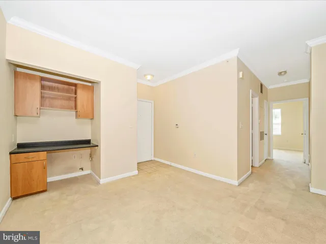 a view of kitchen and empty room with wooden floor