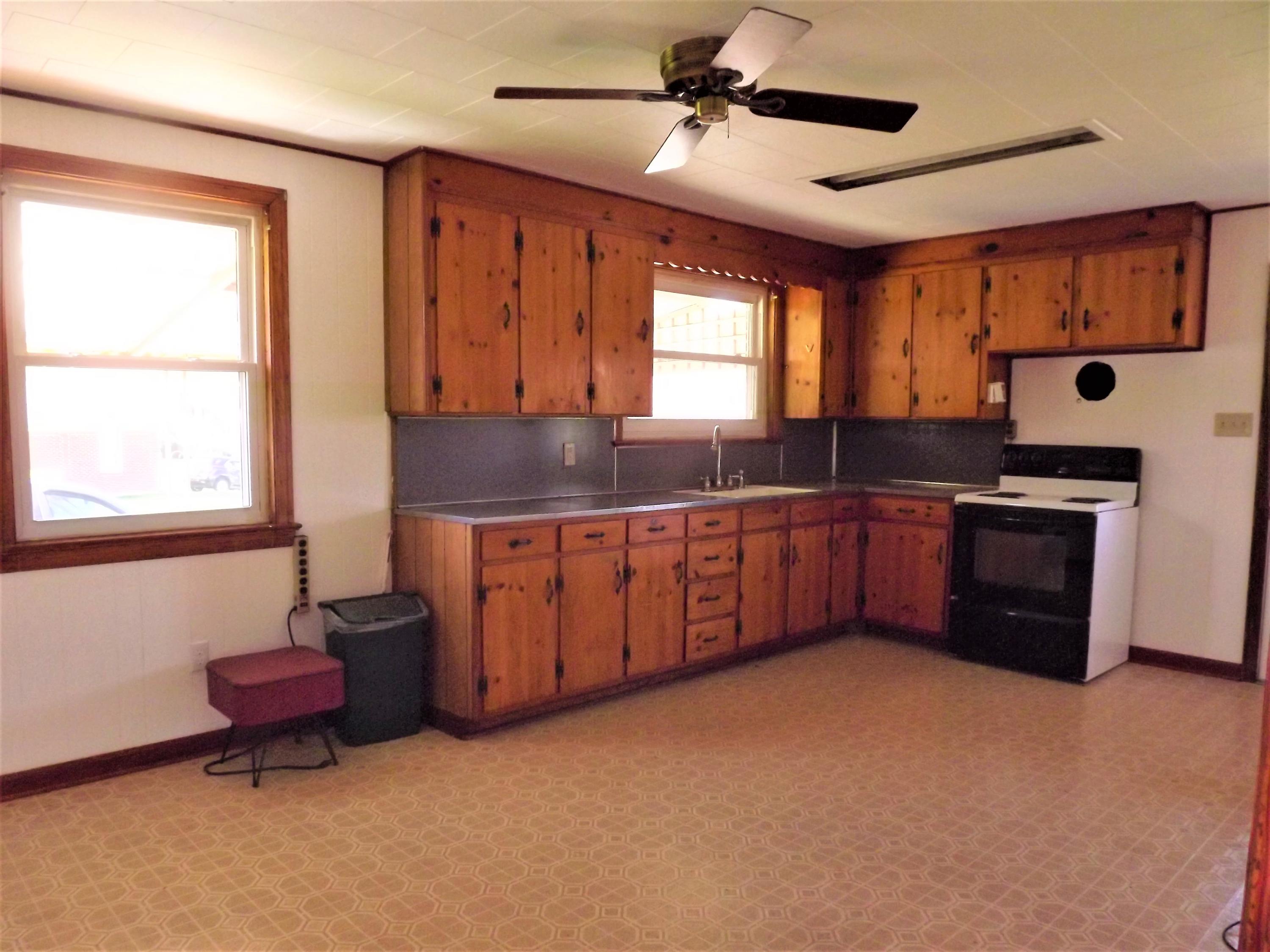 4320 Cove Road Roanoke, VA 24017 - Photo 3 of 10 a kitchen with stainless steel appliances granite countertop a stove a sink and a refrigerator with wooden cabinets