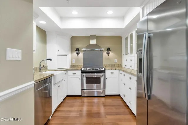 a kitchen with stainless steel appliances granite countertop a stove and a refrigerator