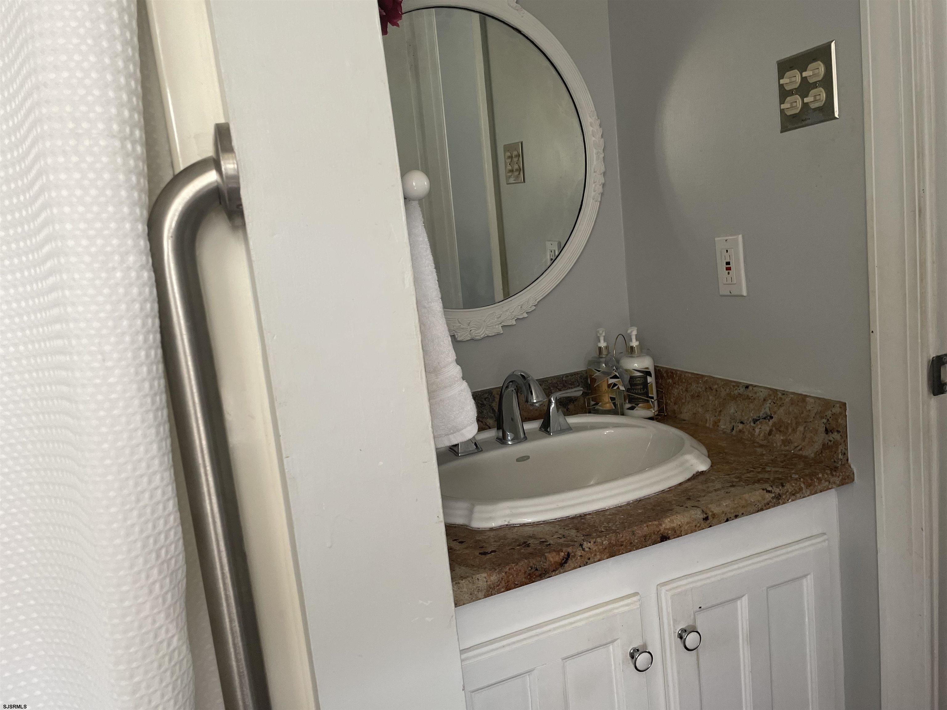 636 Shore Road Somers Point, NJ 08244 - Photo 21 of 25 a bathroom with a granite countertop sink and a mirror