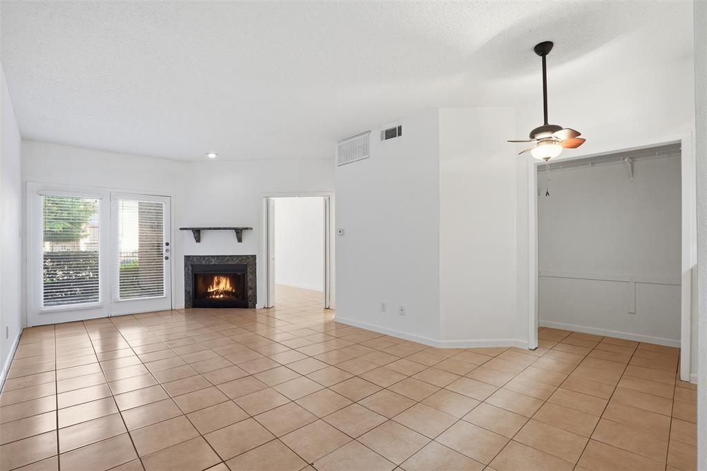 5550 Spring Valley Road, Unit F14 Dallas, TX 75254 - Photo 8 of 15 a view of an empty room with a fireplace and a window