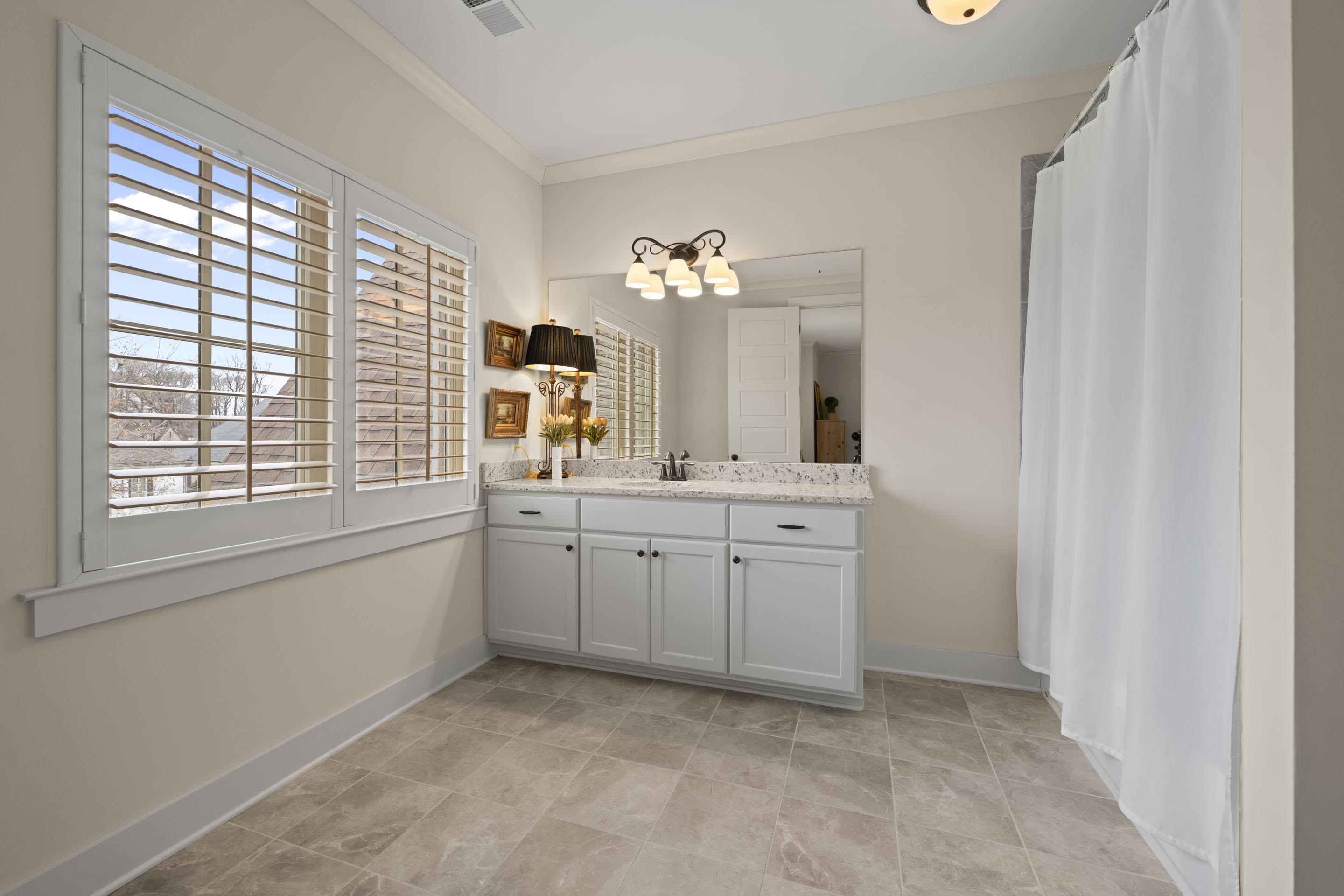 195 Hunters Rest Lane Piperton, TN 38017 - Photo 30 of 36 a spacious bathroom with a granite countertop sink a large mirror and a window