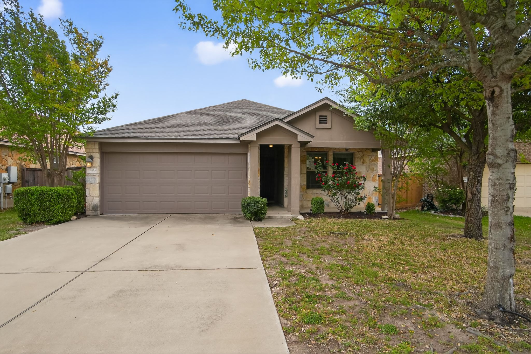 1313 April Meadows Loop Georgetown, TX 78626 - Photo 1 of 21 View of front of house with a shingled roof, driveway, a garage, and stone siding