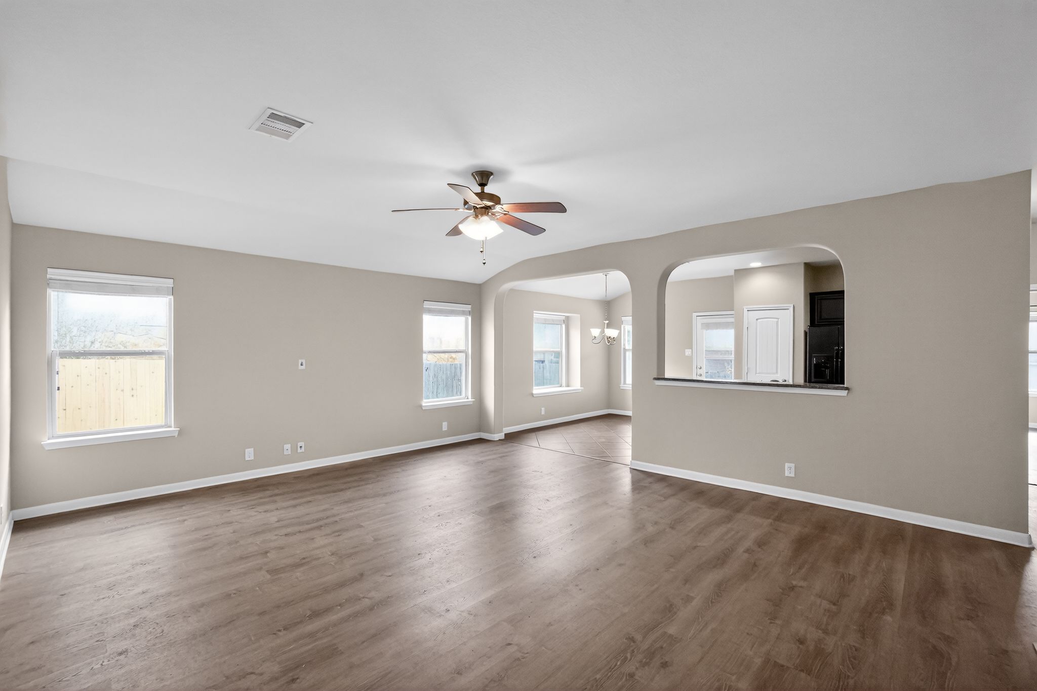 1313 April Meadows Loop Georgetown, TX 78626 - Photo 2 of 21 Spare room with arched walkways, dark wood-type flooring, ceiling fan, and plenty of natural light