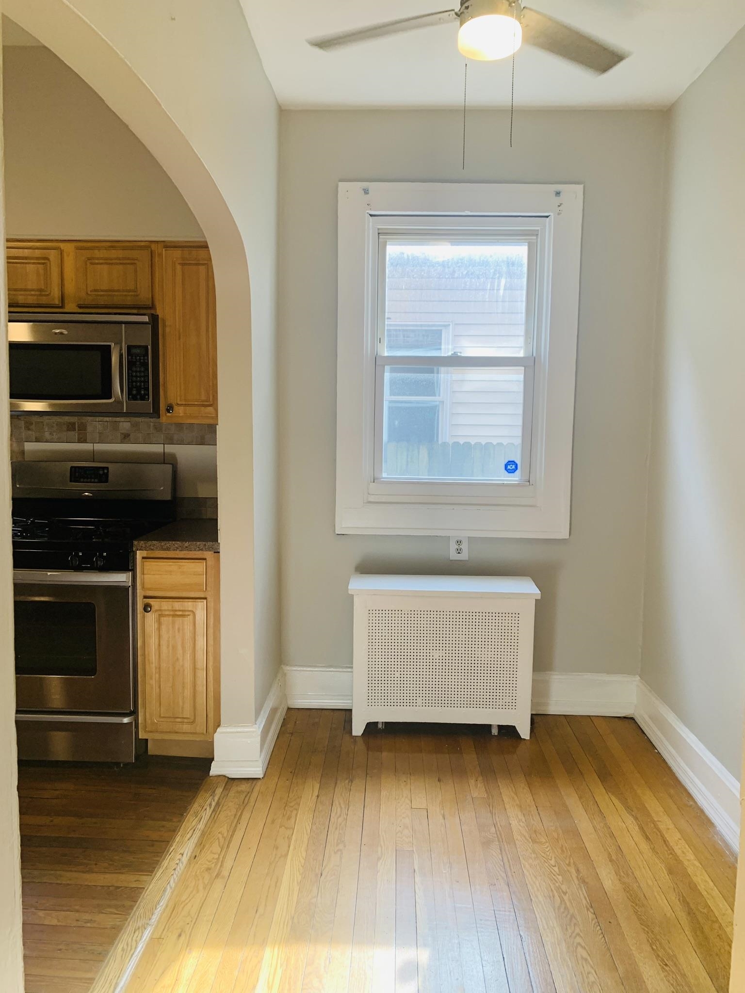 86 West 34th Street, Unit 2 Bayonne, NJ 07002 - Photo 4 of 14 a view of an empty room with wooden floor and a window
