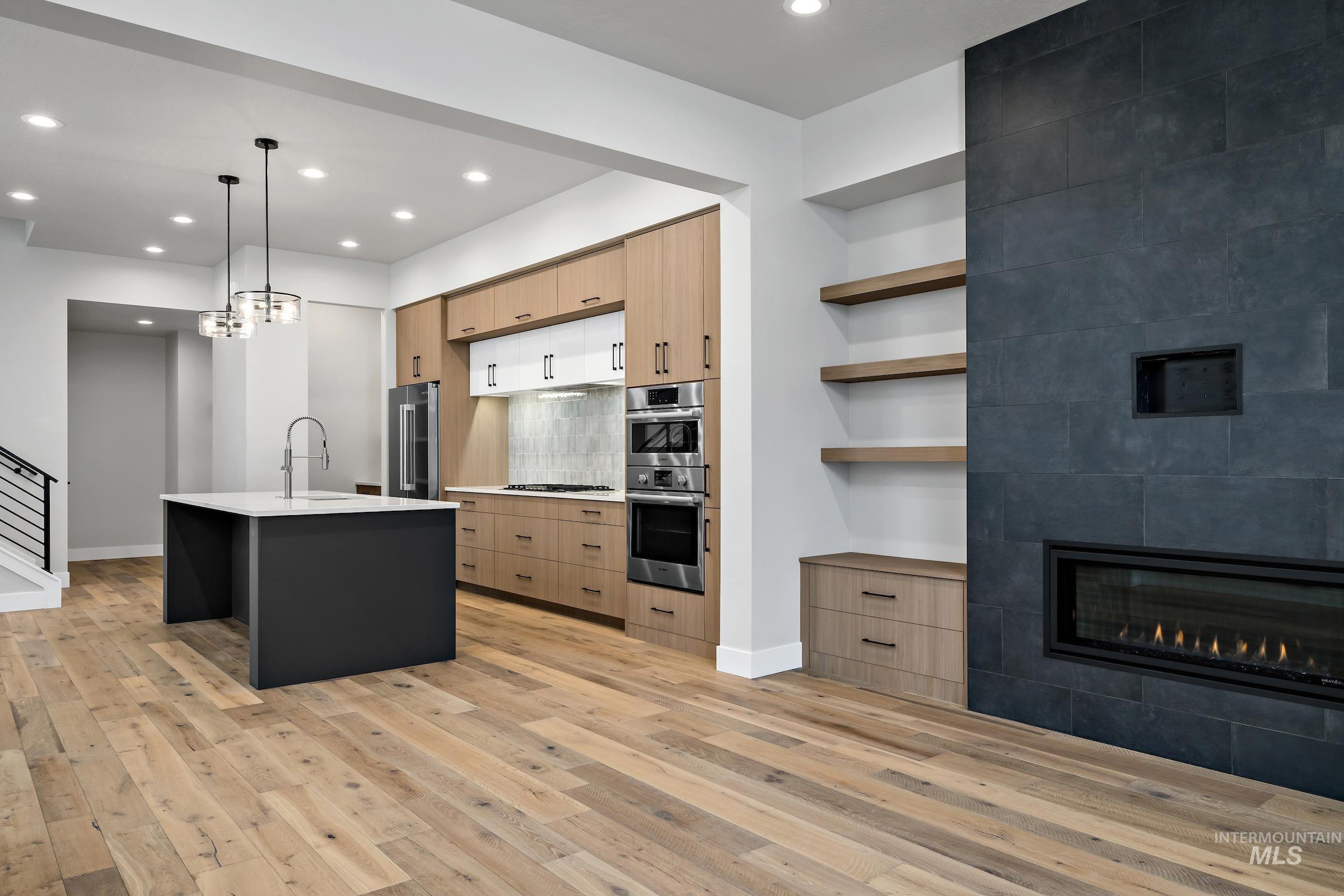 11725 North Rabbitbrush Way Boise, ID 83714 - Photo 13 of 36 Kitchen featuring open shelves, pendant lighting, light brown cabinets, decorative backsplash, and an island with sink