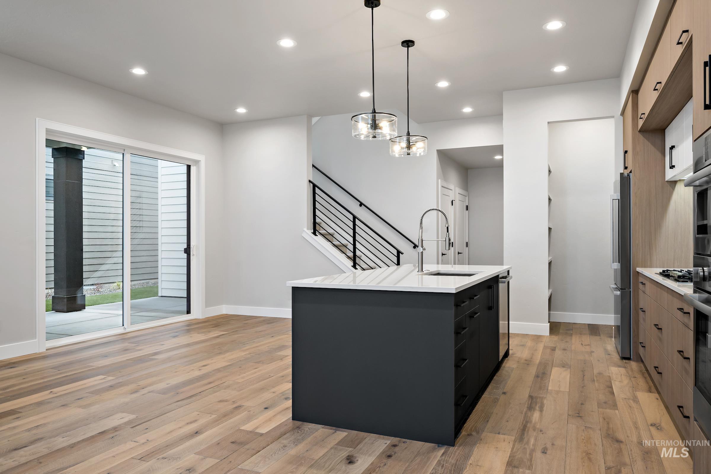 11725 North Rabbitbrush Way Boise, ID 83714 - Photo 14 of 36 Kitchen with pendant lighting, an island with sink, recessed lighting, modern cabinets, and light wood finished floors