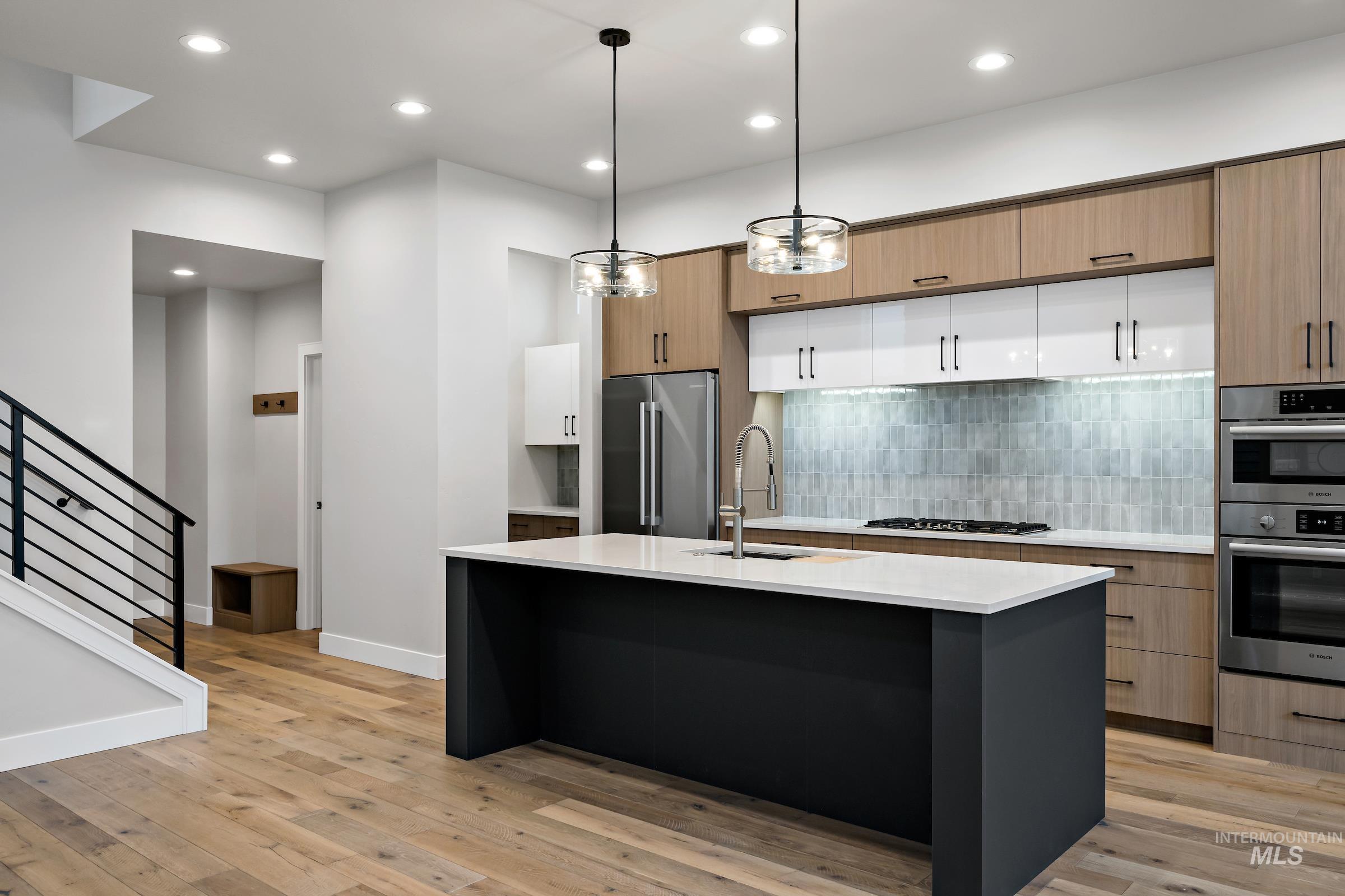11725 North Rabbitbrush Way Boise, ID 83714 - Photo 15 of 36 Kitchen with recessed lighting, decorative light fixtures, modern cabinets, tasteful backsplash, and a center island with sink