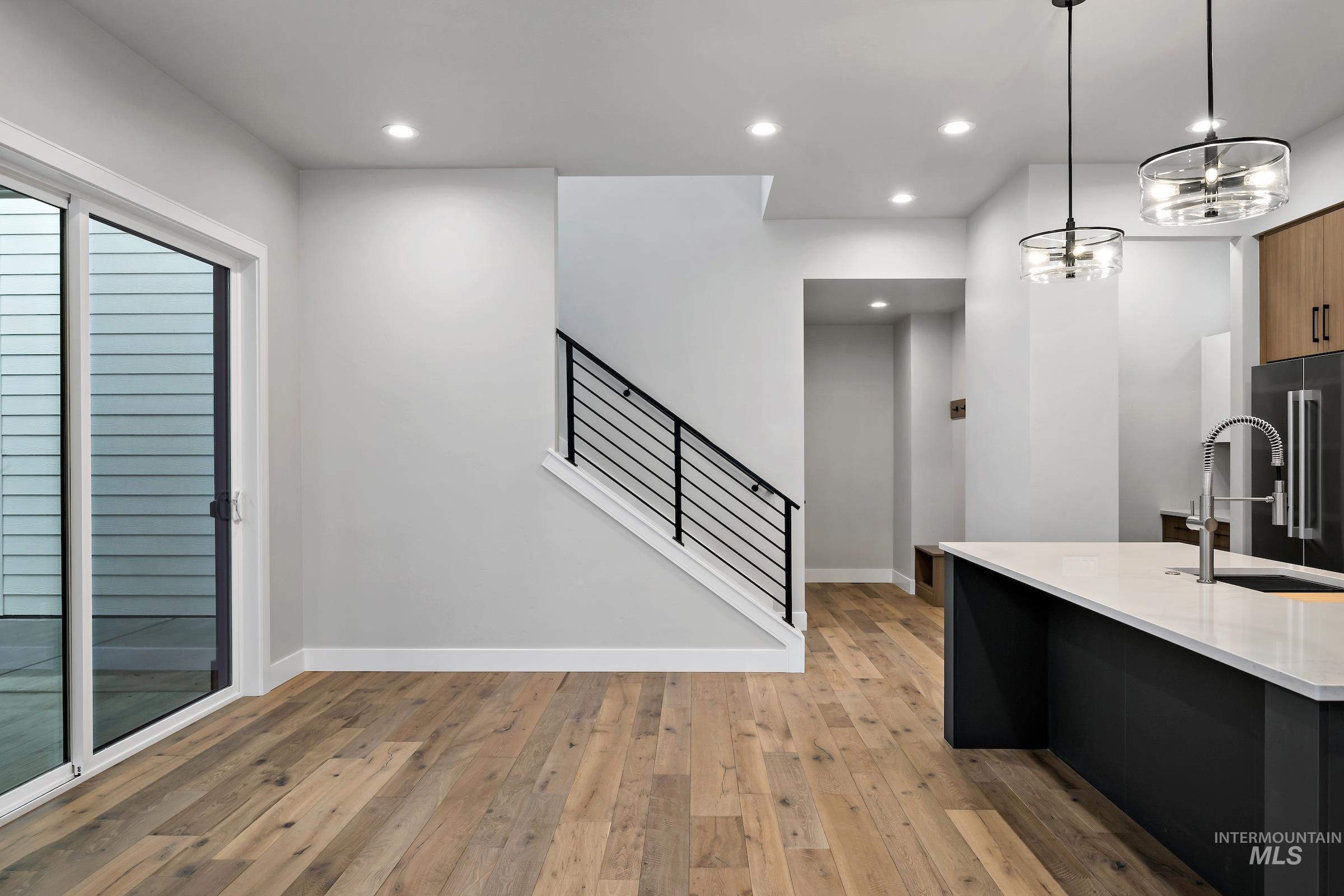 11725 North Rabbitbrush Way Boise, ID 83714 - Photo 17 of 36 Kitchen with recessed lighting, high end fridge, decorative light fixtures, light wood-type flooring, and light stone countertops