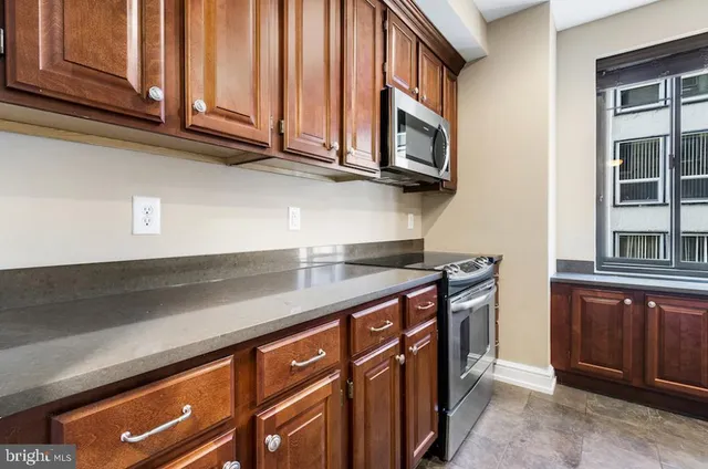 a kitchen with stainless steel appliances granite countertop a sink and a microwave