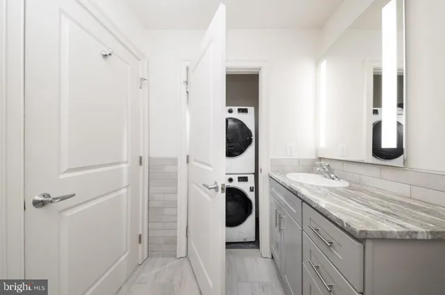 a bathroom with a granite countertop sink and a mirror