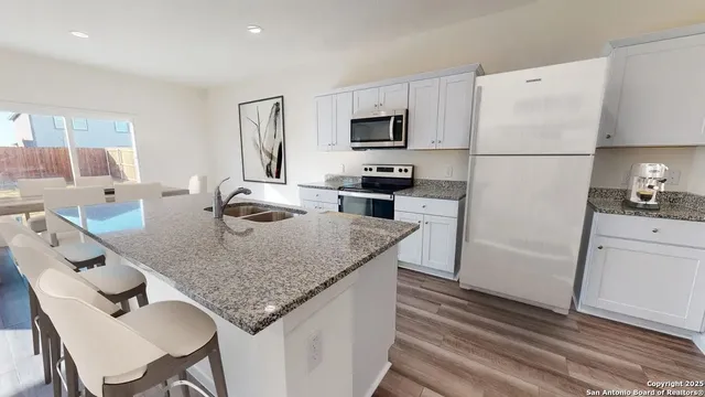 a kitchen with stainless steel appliances granite countertop a sink refrigerator and microwave