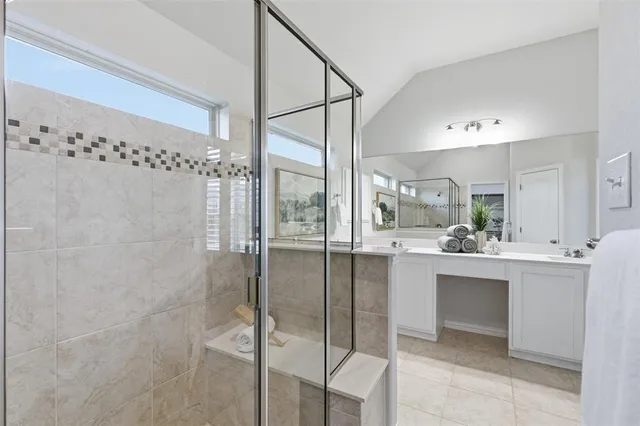 a bathroom with a sink mirror and a shower