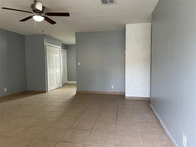 an empty room with closet and a chandelier fan