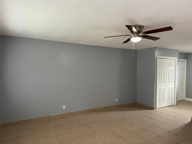 an empty room with a window and a fan