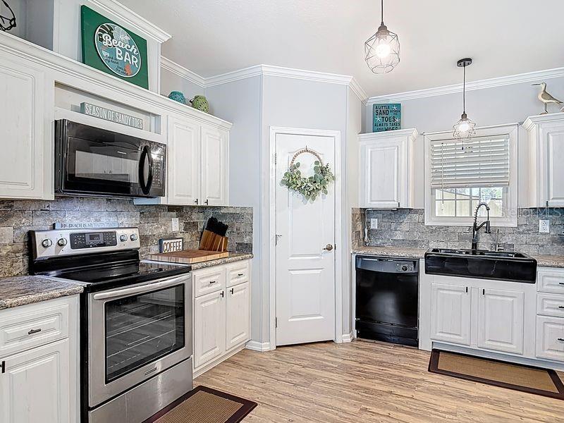 102 Ash Street Edgewater, FL 32141 - Photo 8 of 36 a kitchen with stainless steel appliances granite countertop a stove a sink and a microwave