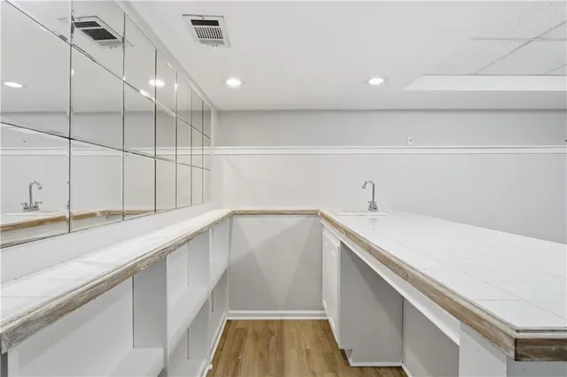 a kitchen with a sink and dishwasher with wooden floor