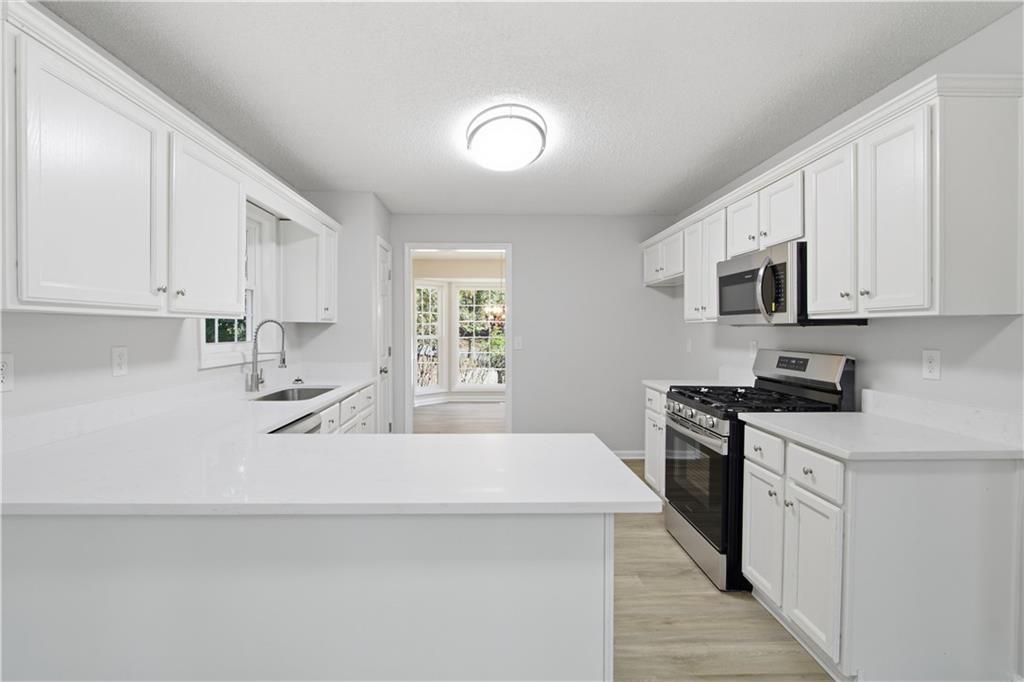 10 Mariner Way Acworth, GA 30102 - Photo 5 of 20 a kitchen with stainless steel appliances a sink stove top oven and white cabinets