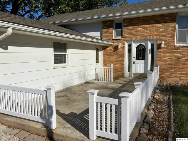 a view of a yard in front of a house with large trees