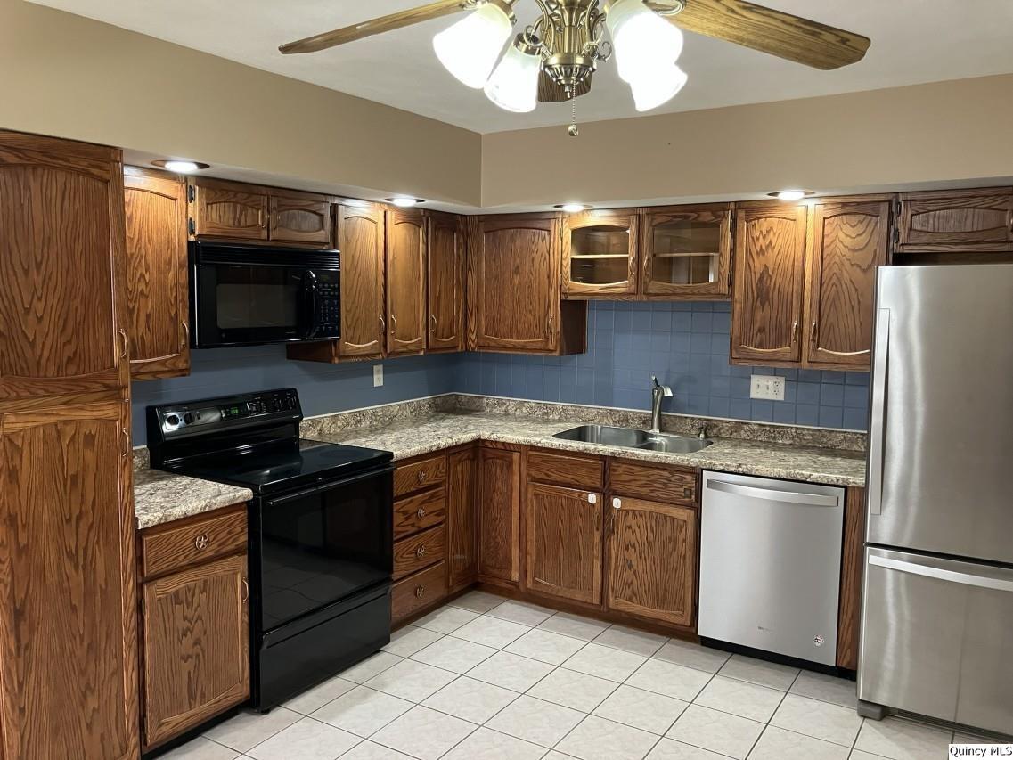 328 North Illinois Street Camp Point, IL 62320 - Photo 3 of 22 a kitchen with stainless steel appliances granite countertop a stove refrigerator and microwave