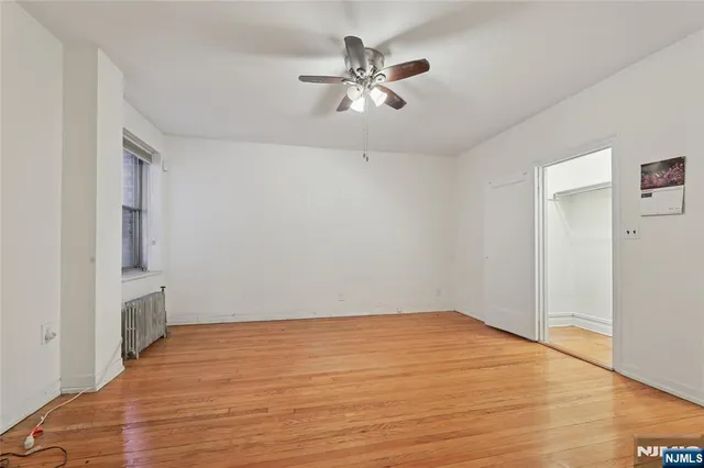 a view of empty room with wooden floor