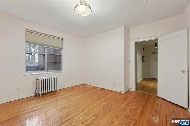a view of a livingroom with wooden floor a fireplace and windows