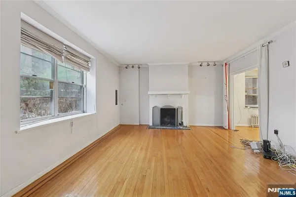 a view of empty room with wooden floor and fireplace