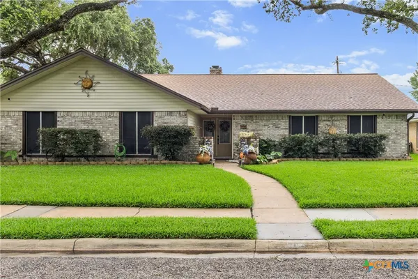 a front view of a house with a garden and plants