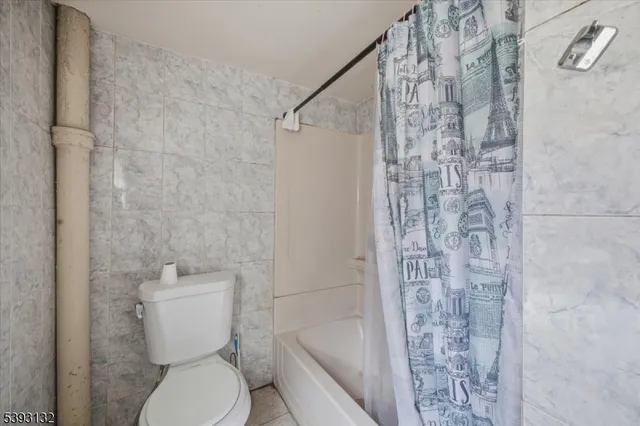 a white toilet sitting next to a shower curtain
